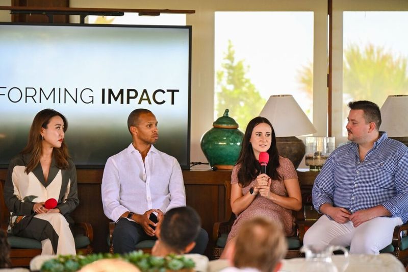 Ania Wysocka speaking on a panel of four at an event, with a screen reading "Forming Impact" in the background