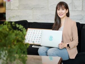 Woman holding a laptop while sittng