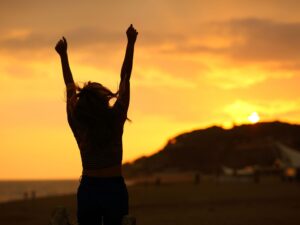 A lady stopping to celebrate in front of mountains
